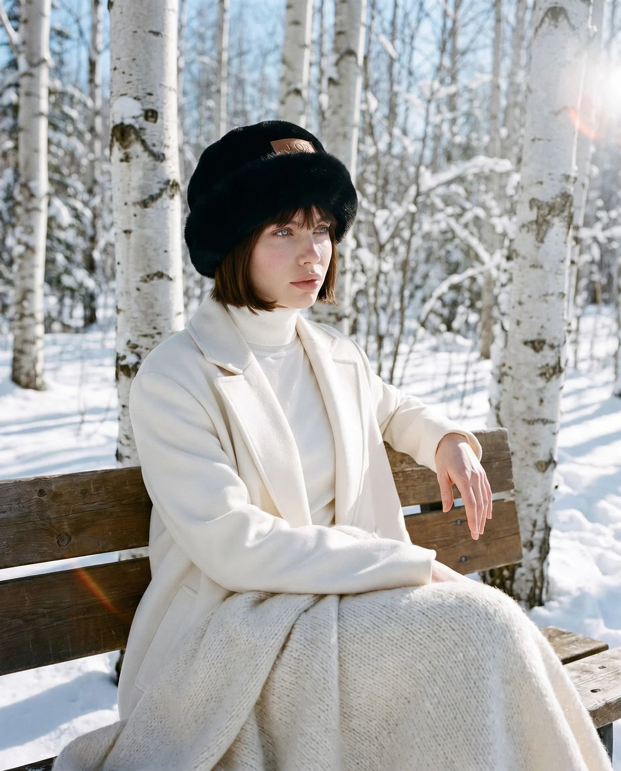 Boreal Hat negro en modelo, sentada en banca con manta